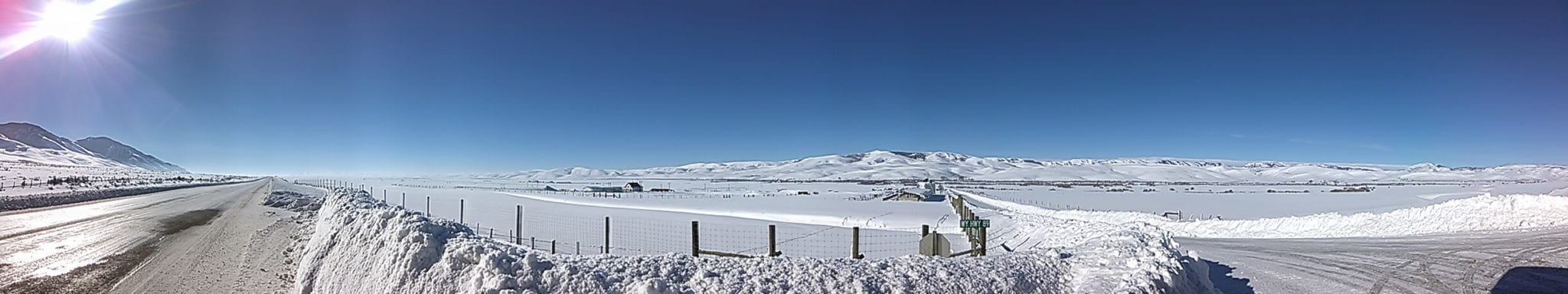 This is a picture of deep blue sky, white snow covering the prairie a fence cuts through the picture. Expansiveness.