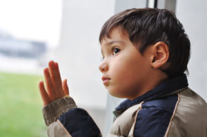 Young boy looking out a window