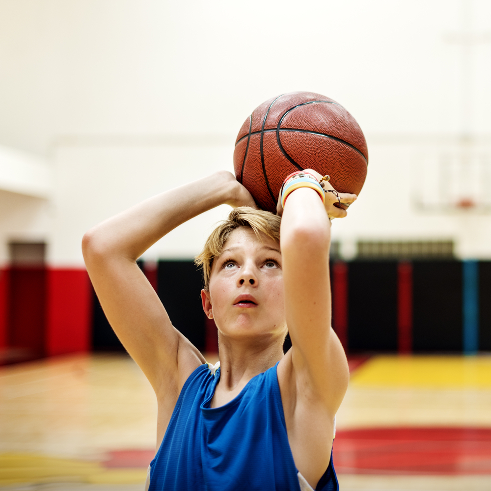 boy shooting basketball