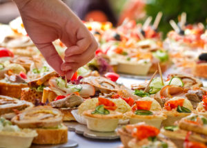 Hand reaching into buffet food