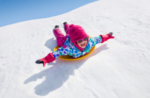 Girl sledding down a hill