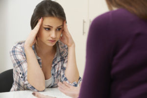 Girl looking distressed with counselor