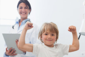 Little boy with arms up in doctors office