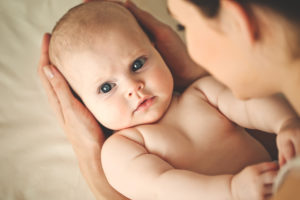 Newborn in hands of mother.