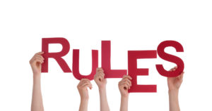 Hands holding up the letter for the word rules.