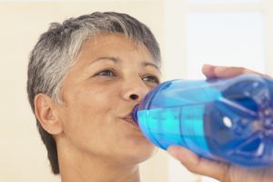 Woman drinking out of a water bottle