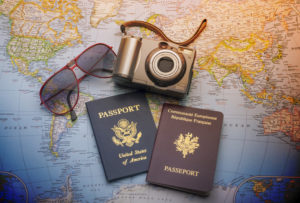 Two passports on a map with camera and sunglasses