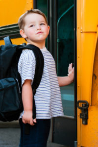 photo of boy getting on bus