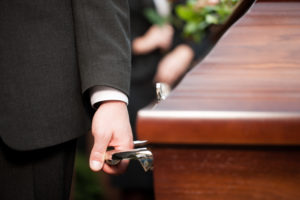 Hands carrying a casket