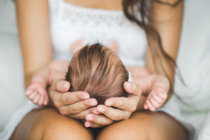 Newborn baby on lap, newborn screening panel