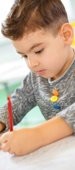 boy drawing with red pencil