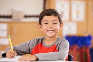 boy smiling at school desk