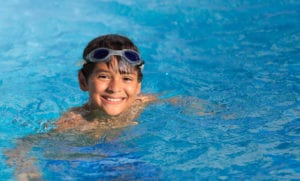 photo of boy with goggles in pool