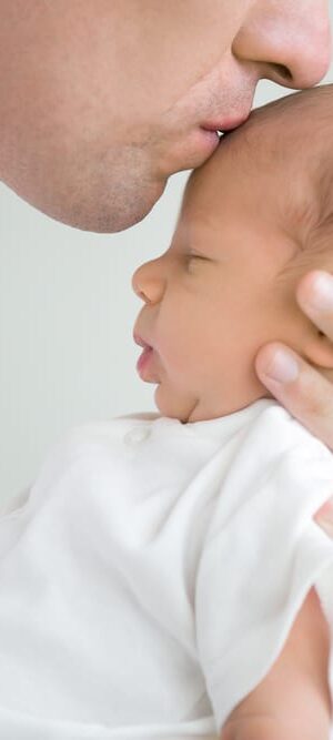 dad kissing newborn