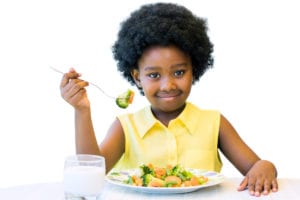 photo of girl eating vegetables