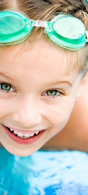 girl with swimming goggles in pool