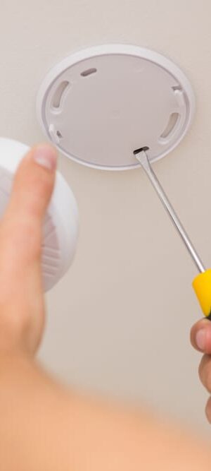 hand putting in smoke detector
