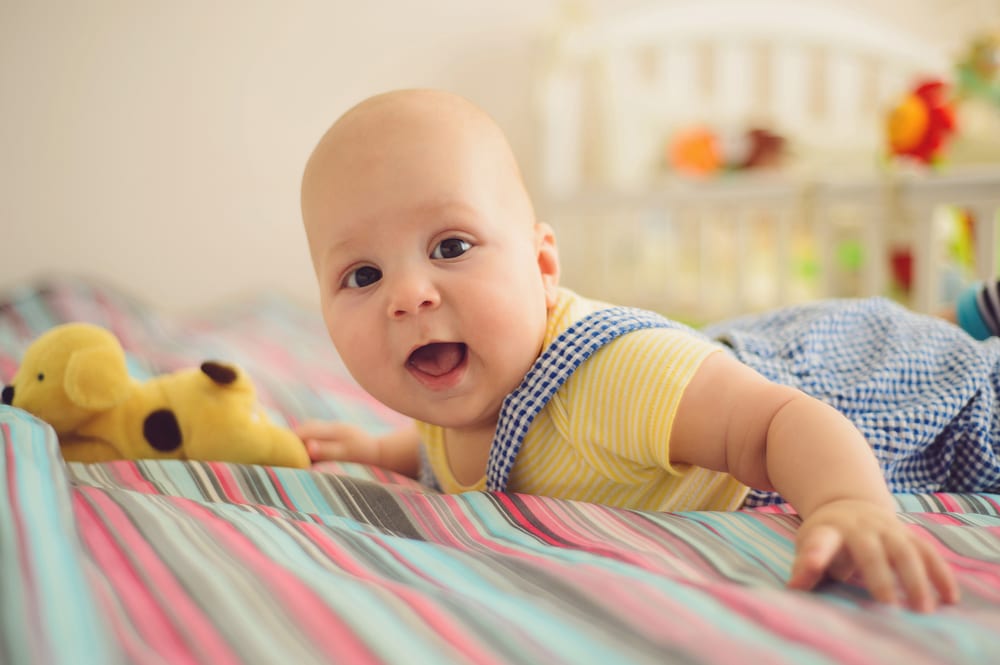 happy baby on bed - Wyoming Department of Health