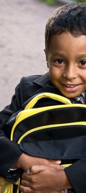 happy boy holding backpack