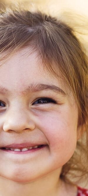happy little girl smiling outdoors