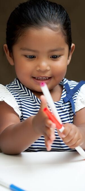 little girl with markers