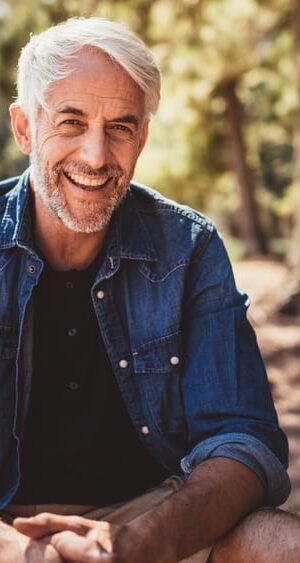 older man outdoors by lake