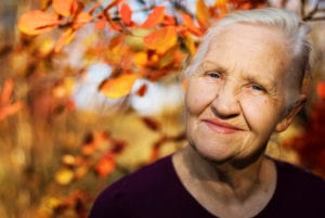 Photo of older woman with fall leaves