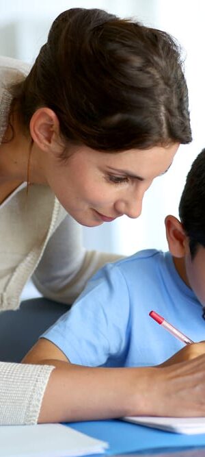 teacher helping young boy