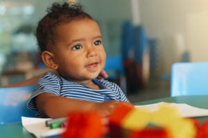 Toddler with toys at daycare.
