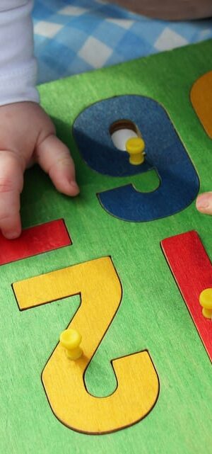toddler hands with number puzzle