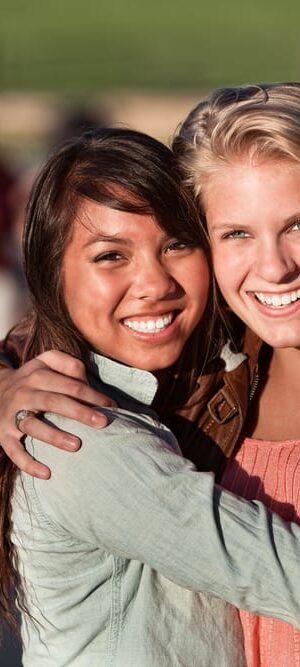 two teen girls hugging