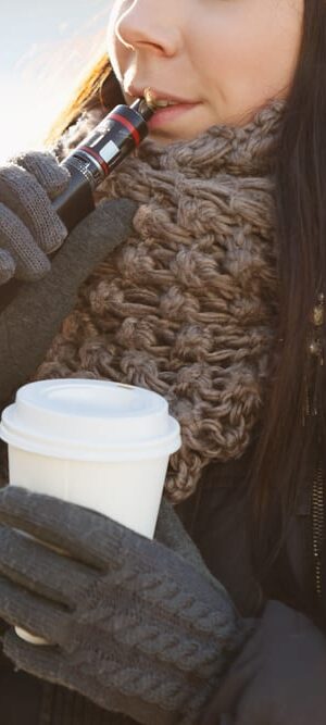 woman vaping and drinking coffee