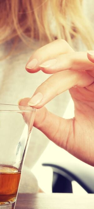 woman’s hand on whiskey glass