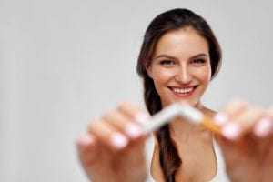 young woman breaking cigarette