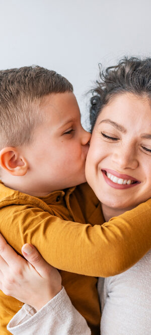 boy kissing mom on cheek