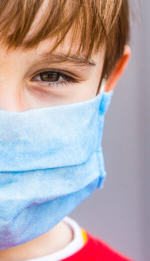 boy with red shirt and face covering