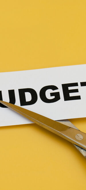 budget on paper with scissors