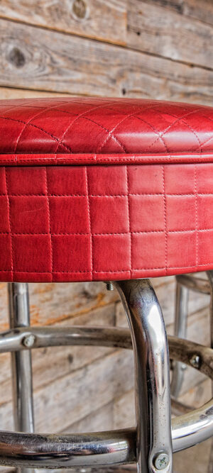 empty red stools at bar