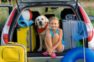 girl and dog in car
