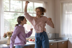 girl and mom dancing in kitchen