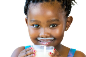 girl smiling with glass of milk