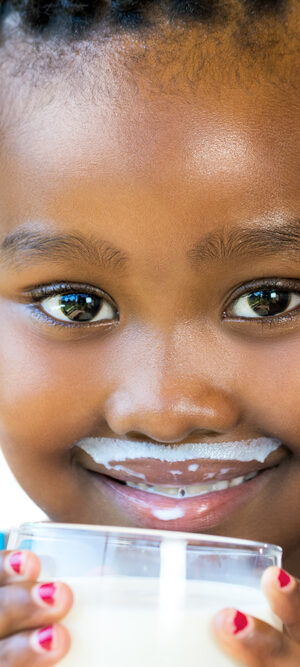 girl smiling with glass of milk