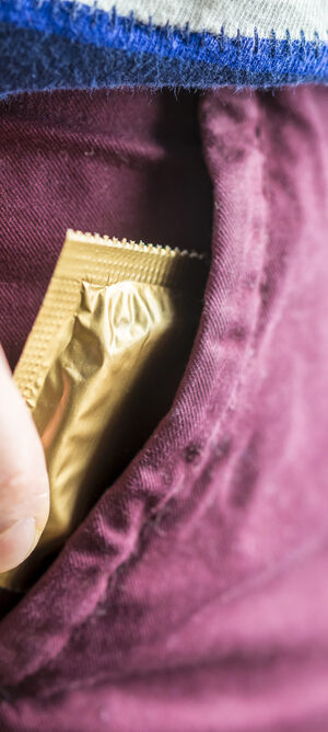 hand putting condom in pocket