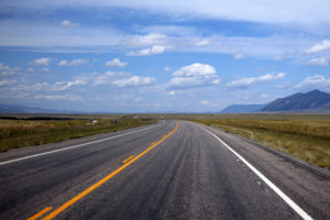 highway running through a valley with hills
