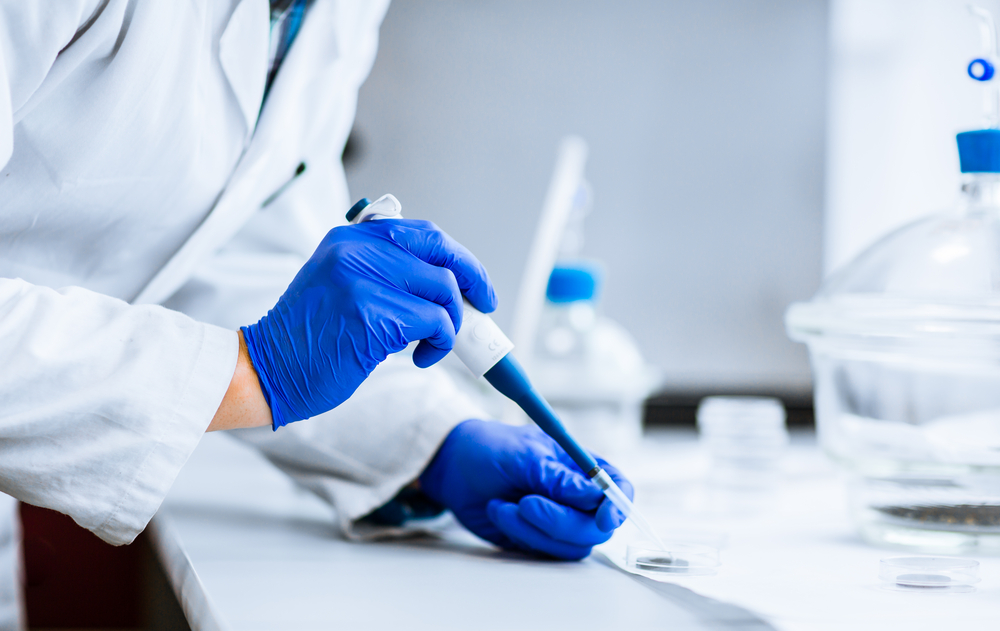 lab worker with blue gloves - Wyoming Department of Health