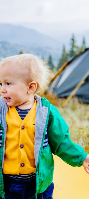 little boy by camping tent outdoors