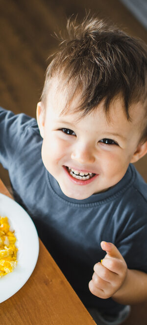 little boy eating eggs