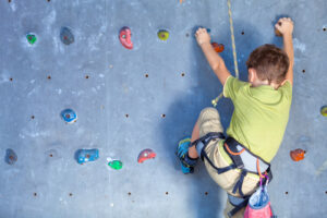 little boy on rock climbing wall
