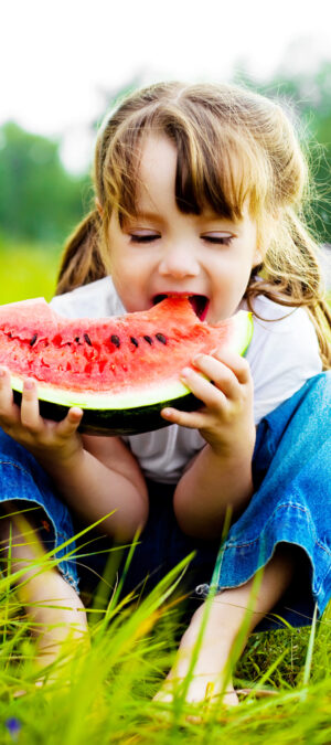 little girl eating big watermelon slice