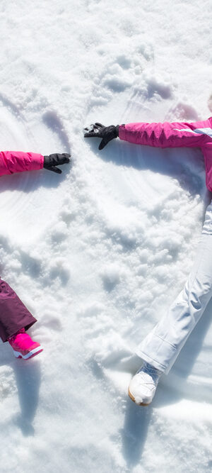 making snow angels with pink jackets